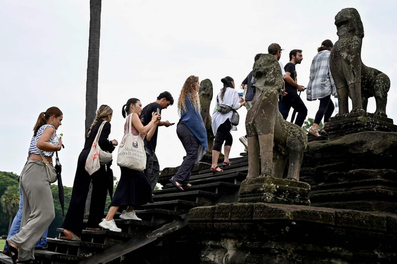 Tourists are ascending the steps of a temple.