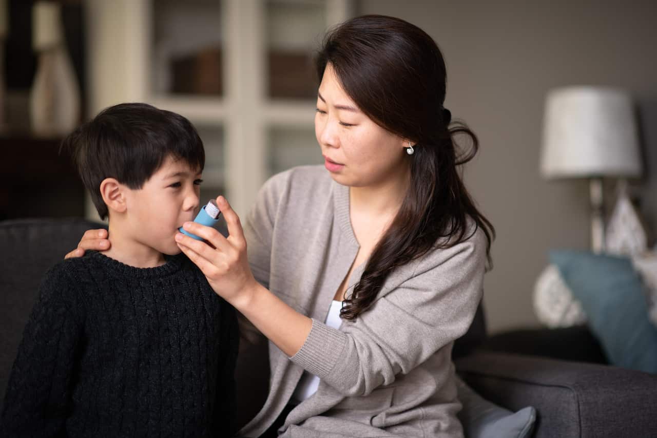 Mother helping asthmatic son