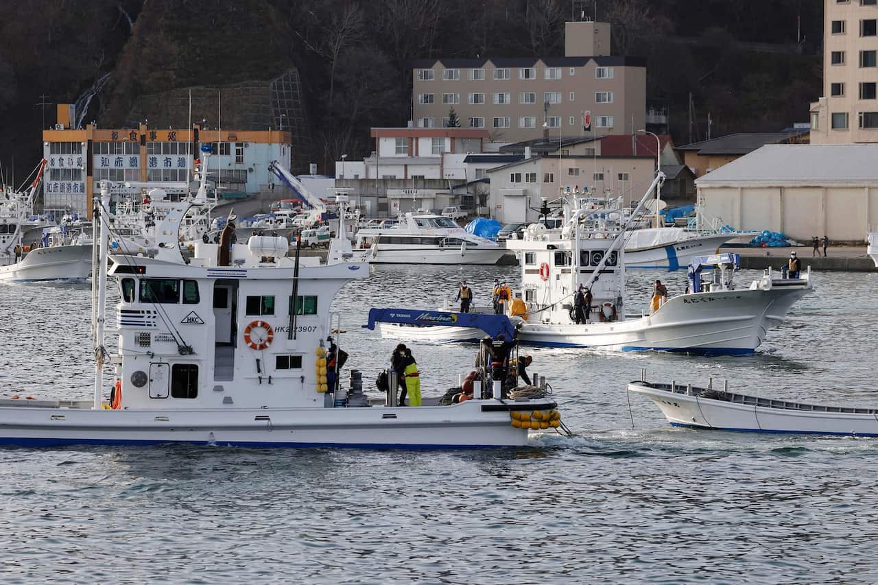 Fishing boats leave a port to search for a missing tour boat on 24 April 2022.  