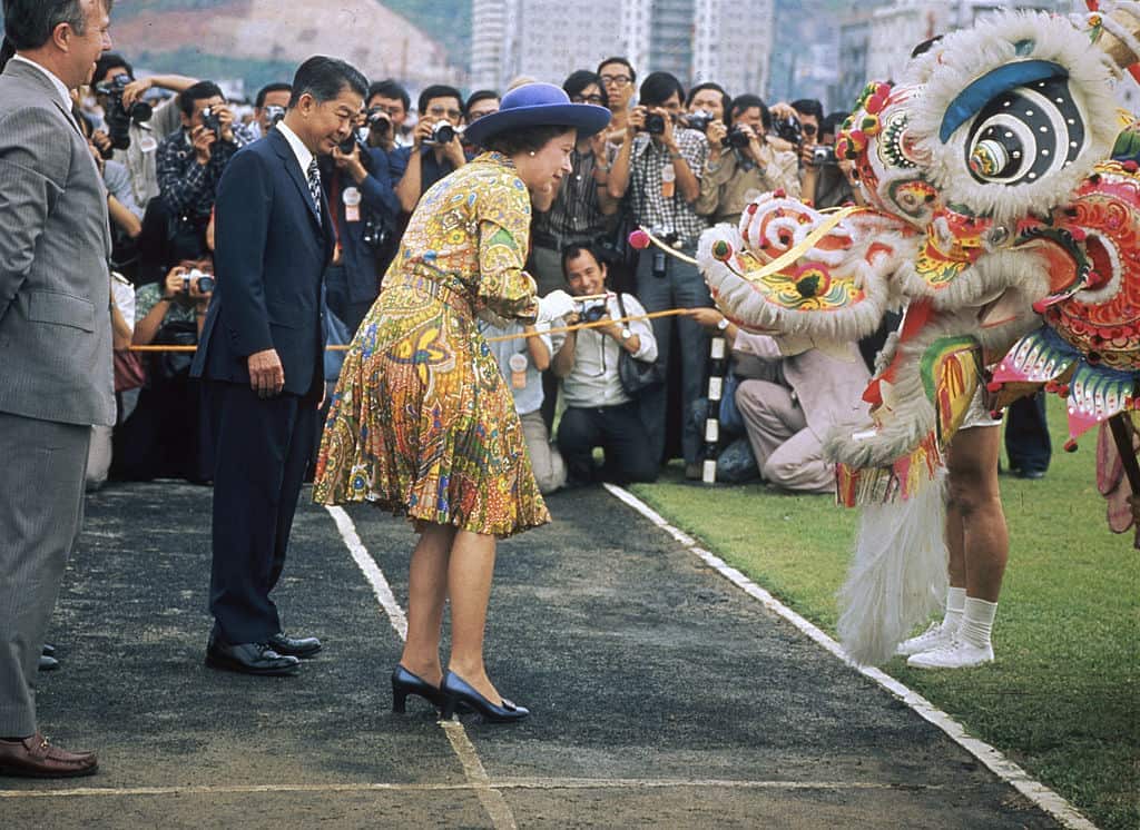 Queen kneels down to meet Chinese dragon