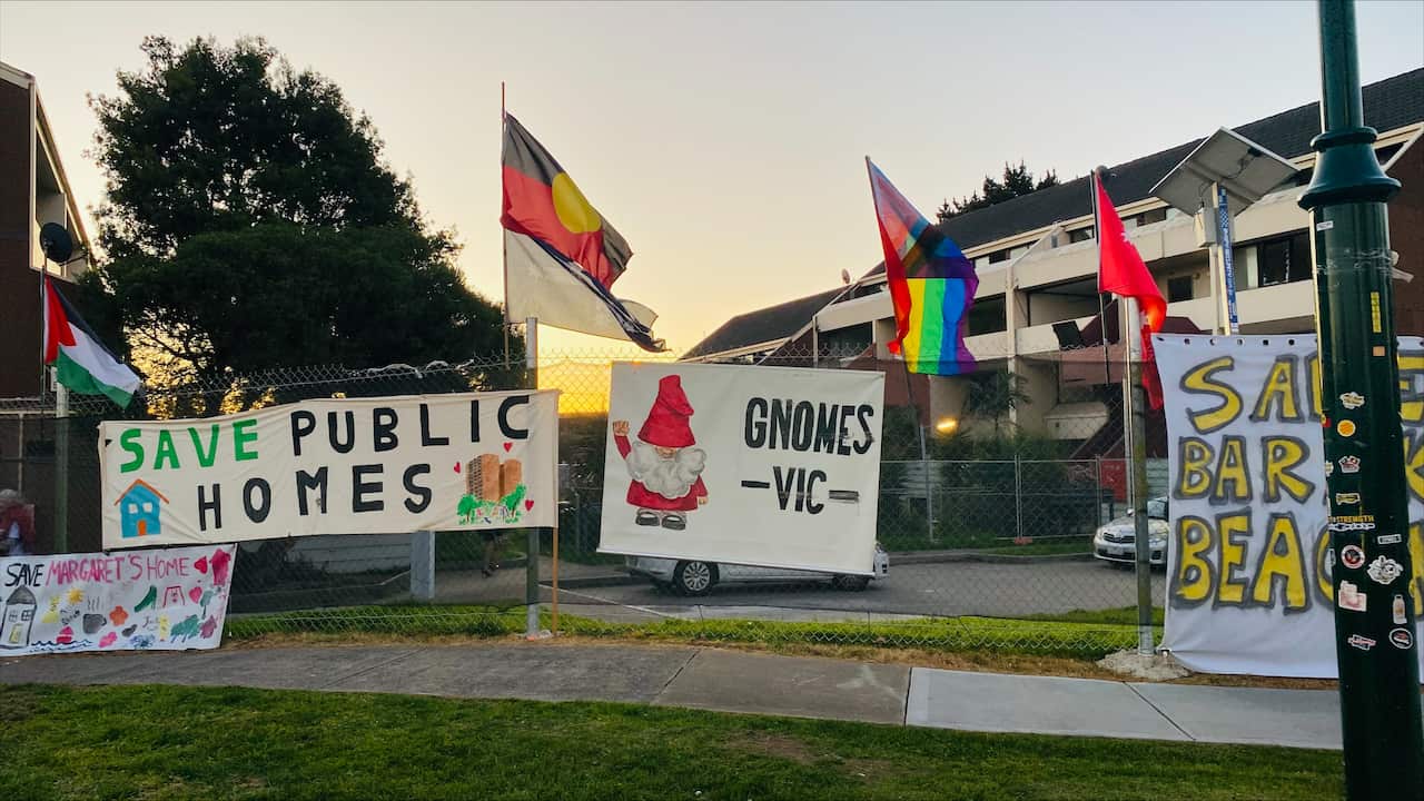 Posters advocating to save public homes attached to a fence.