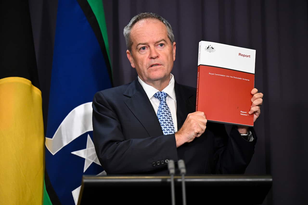 Man in suit holds up a document.