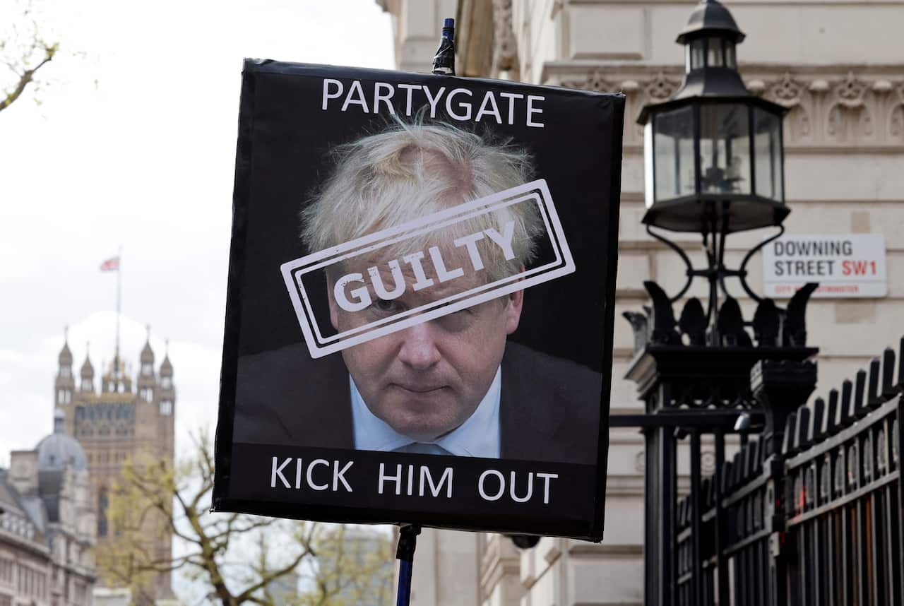 The face of a man on a placard that reads "guilty", "partygate" and "kick him out"