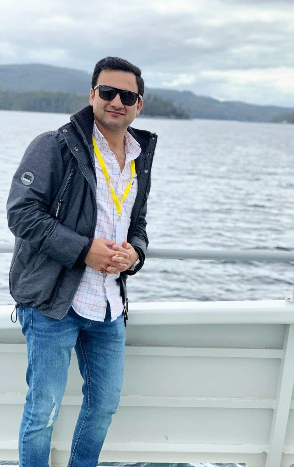 Man in sunglasses standing on boat.