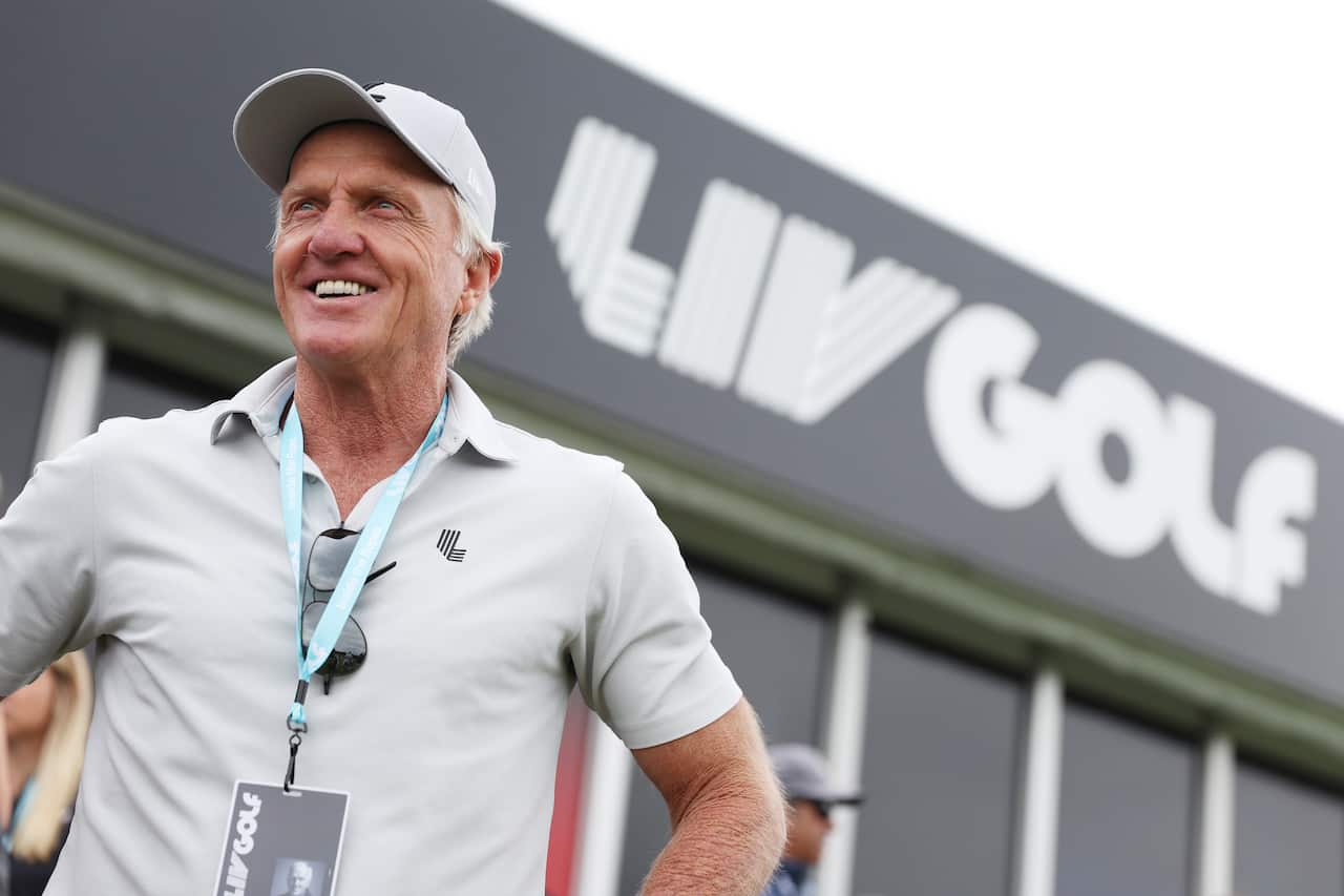 Greg Norman, CEO and commissioner of LIV Golf, smiles in front of the LIV Golf branding 