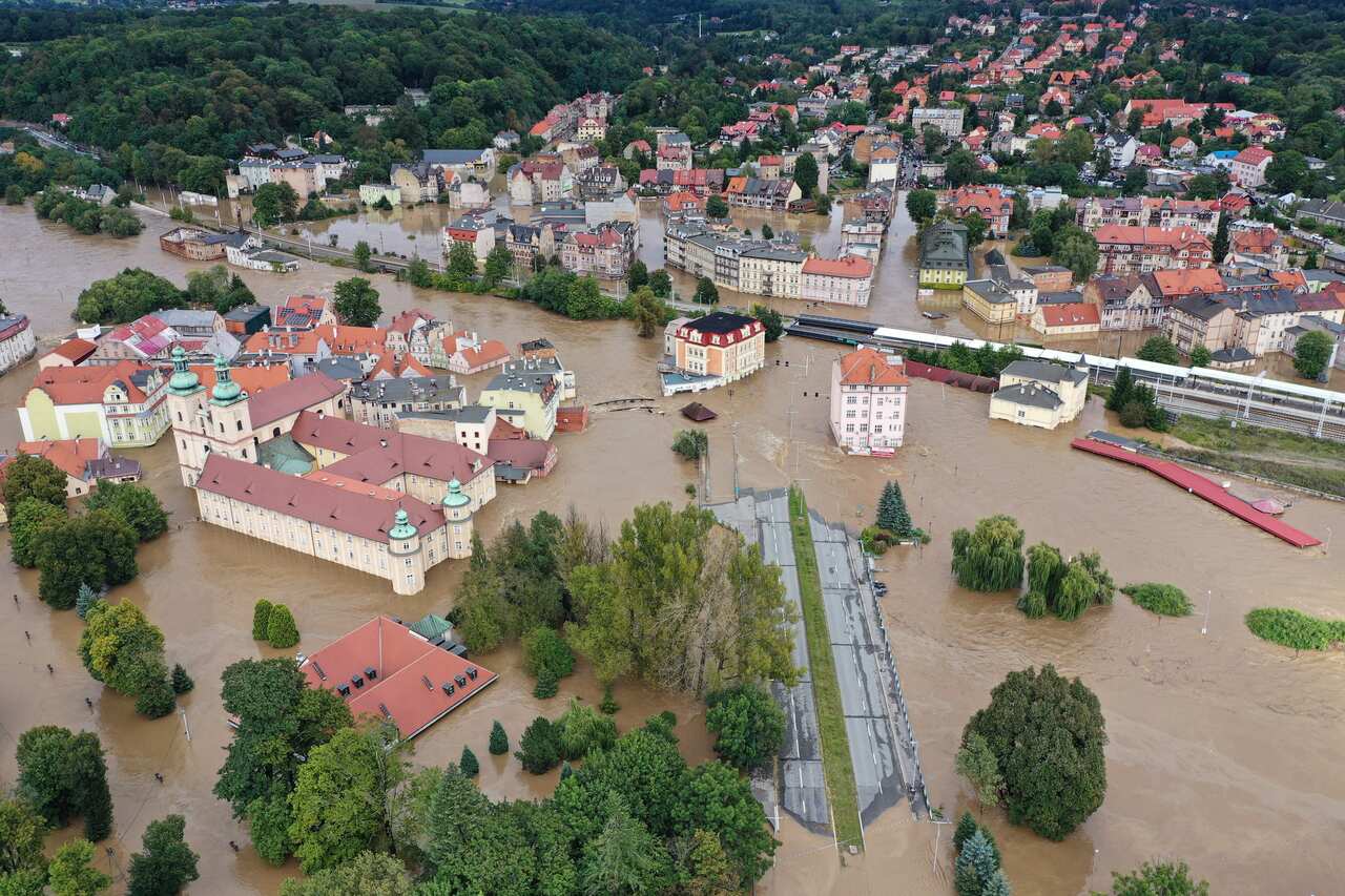 Coloured roofs of buildings and trees peaking through murky floodwaters.