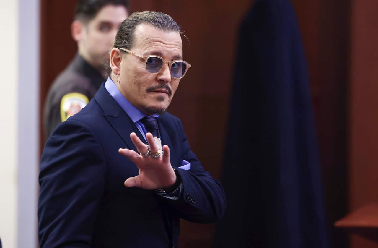 A man making a gesture with his hand while working.