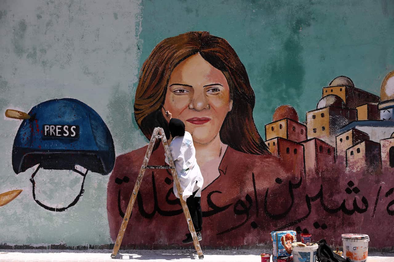 A Palestinian artist paints a mural in honour of slain Al Jazeera journalist Shireen Abu Aqla in Gaza City.