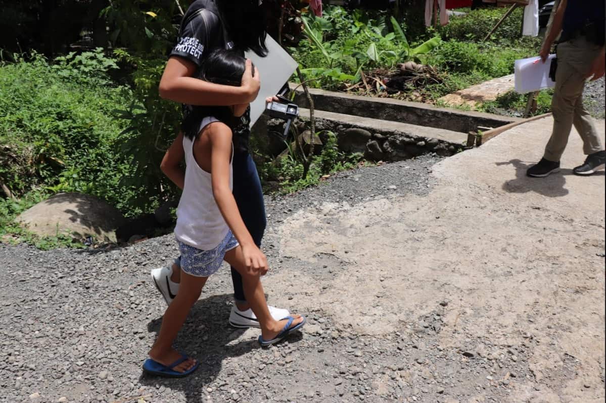 One of Schapel's victims is escorted away by police after being rescued. 