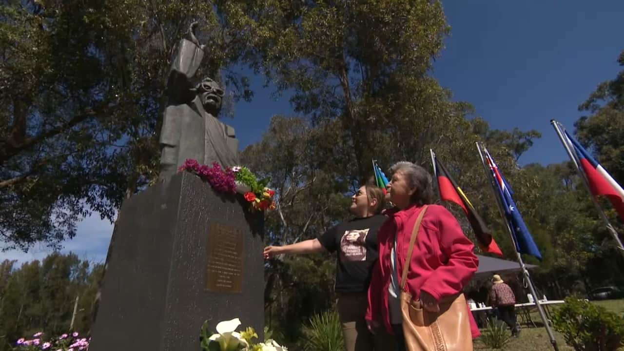 Chilean Australians standing at the foot of a statue of Salvador Allende.