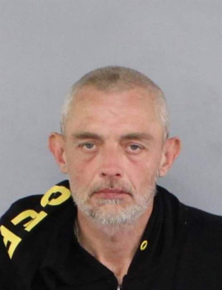 A portrait shot of an elderly man wearing a dark t-shirt.