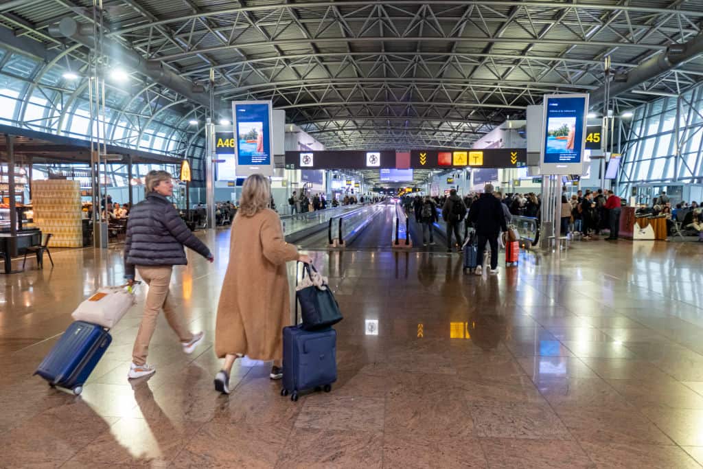 People with bags in an airport terminal 