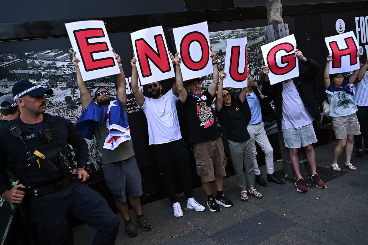 People hold up placards at a protest rally