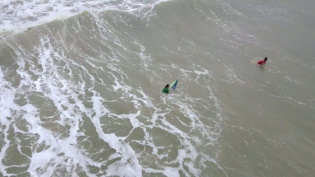 An aerial photograph of a wave and a surfer.