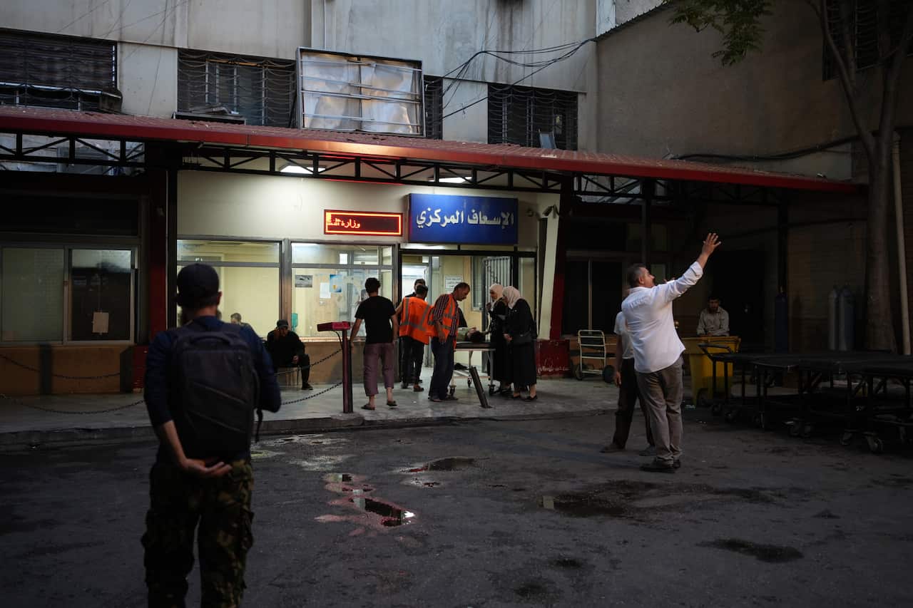 People are walking towards a hospital.