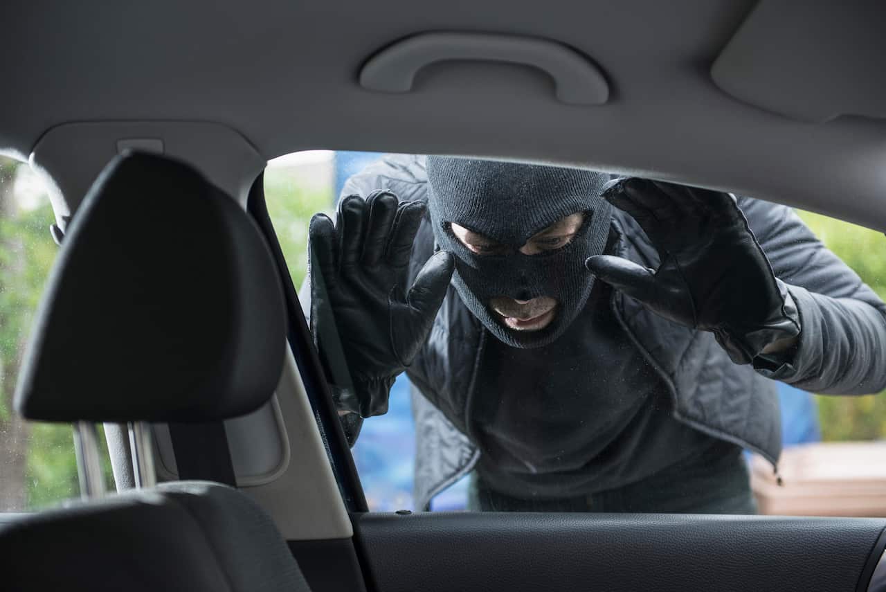 Thief peeking into a car