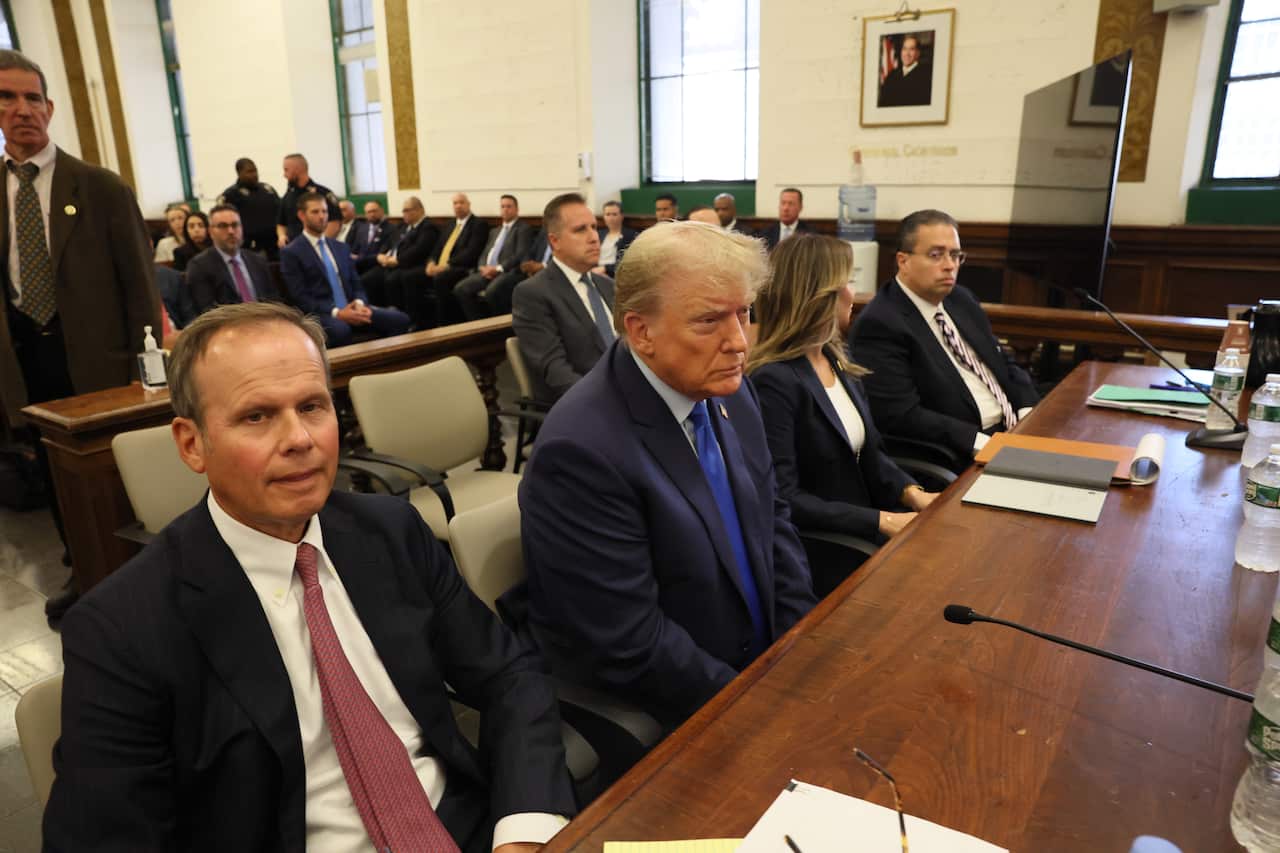 Former US President Donald Trump sitting next to his two eldest two sons and his attorney inside the State Supreme Court of New York.