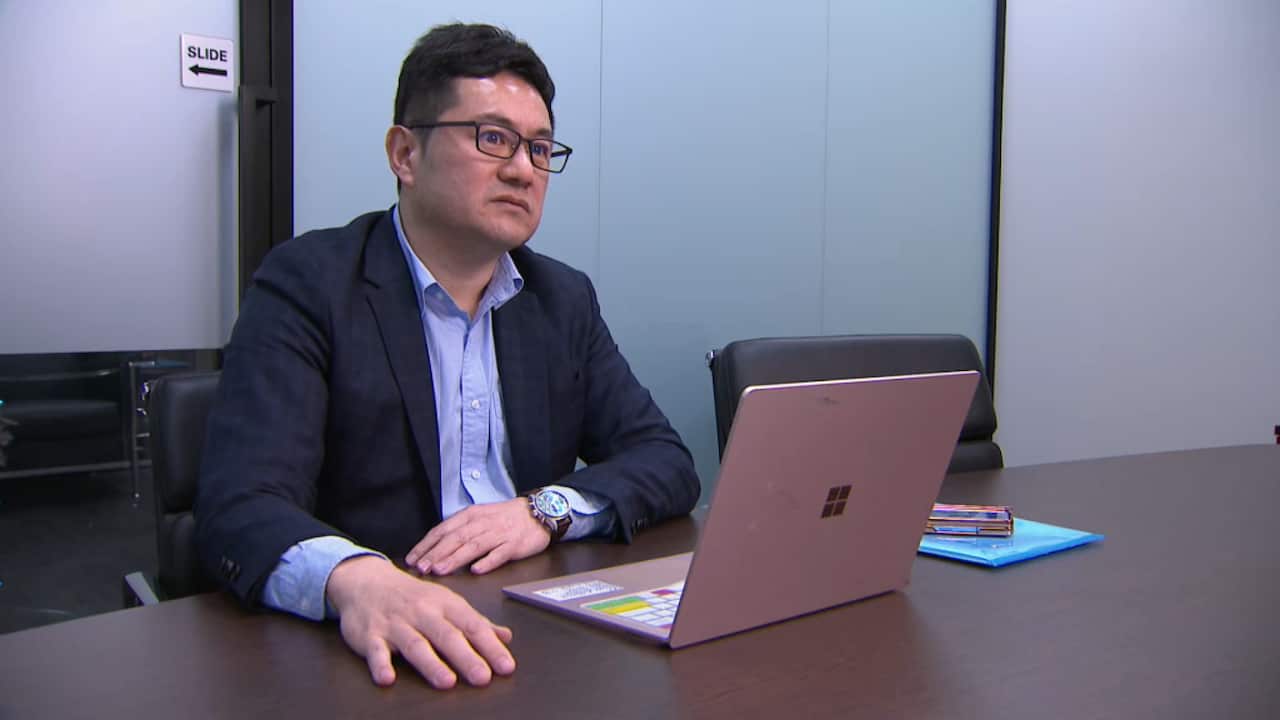 A man sitting at a desk with a laptop