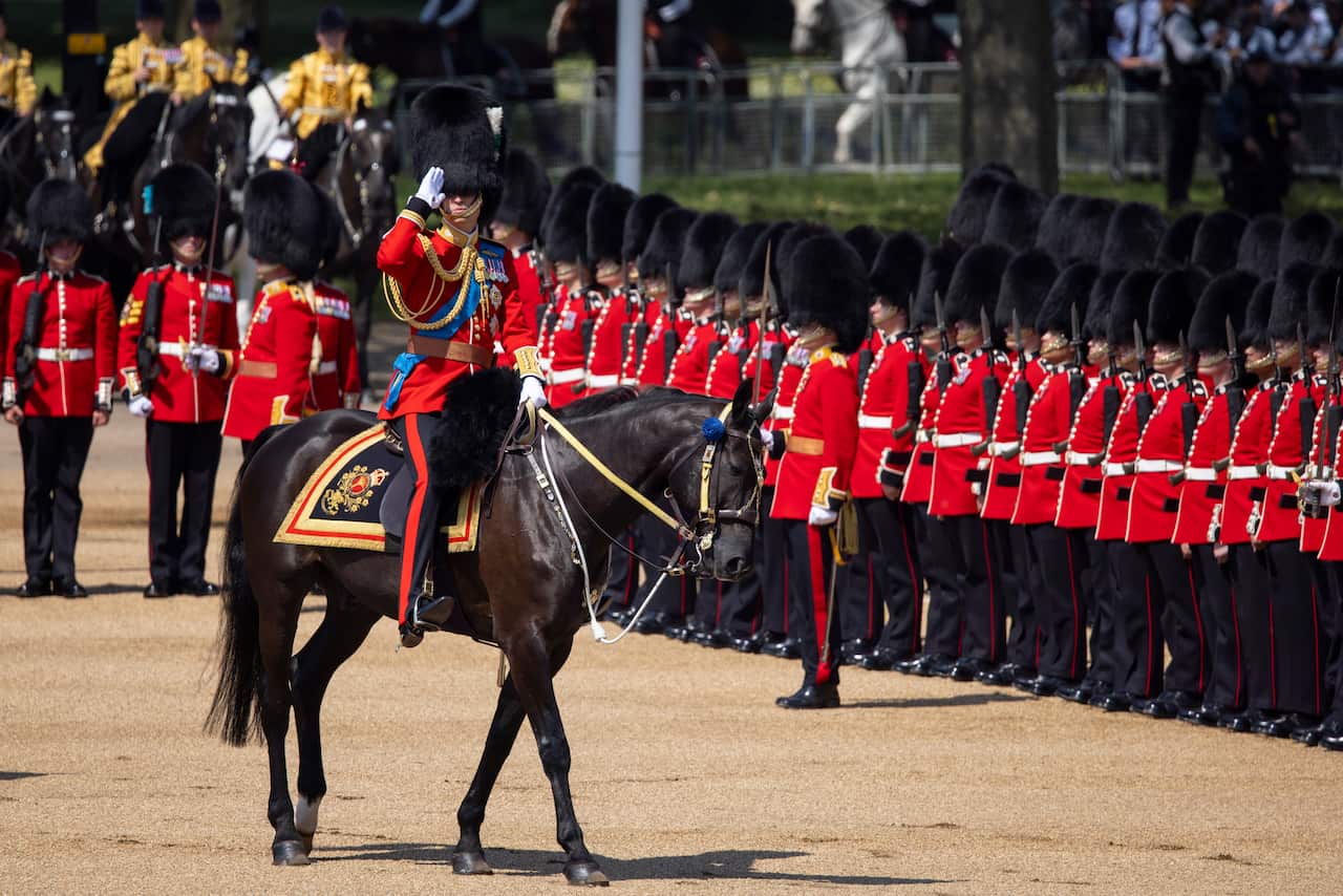 A man on a horse saluting in front of soldiers.