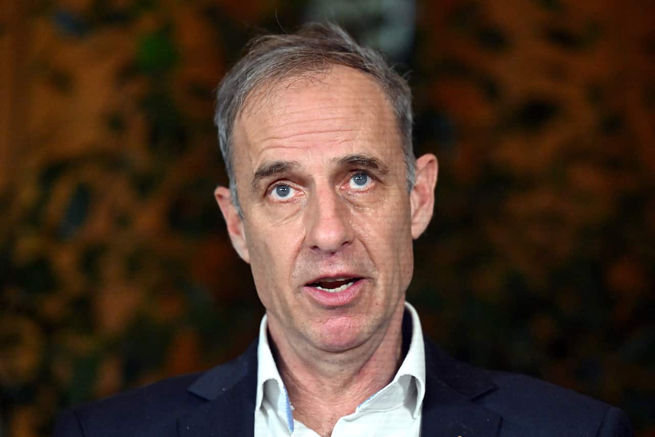 A man with grey hair and a suit speaking.