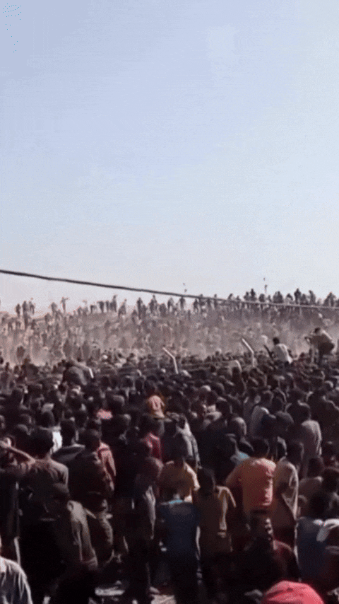 A video of a frenzied crowd scaling fences.