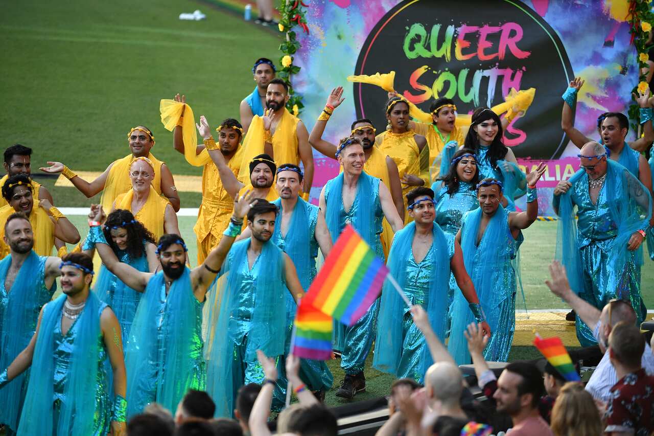 Participants in the Sydney Mardi Gras parade with a sign reading 'Queer South Asians'. 