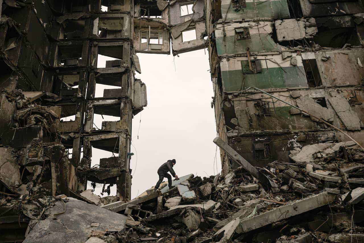 A resident looks for belongings in the ruins of an apartment building destroyed during fighting between Ukrainian and Russian forces in Borodyanka, Ukraine