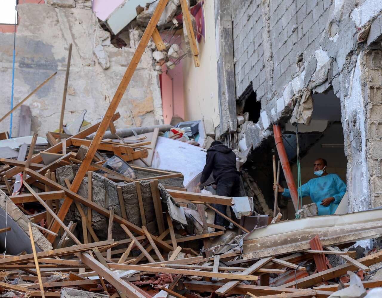 People inspect the damage to a Gaza hospital after Israeli occupation