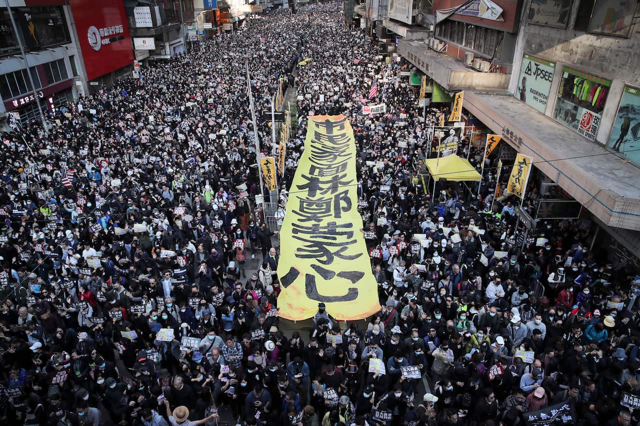 Birds eye view shot of thousands of people on the street. A pro-democracy protest is being held. 