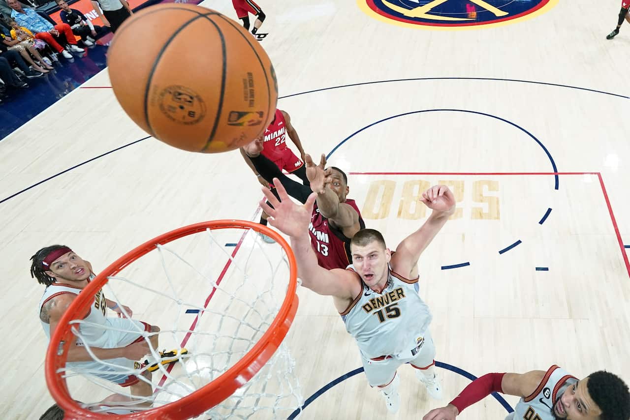 A man attempting to shoot a goal during a basketball match.