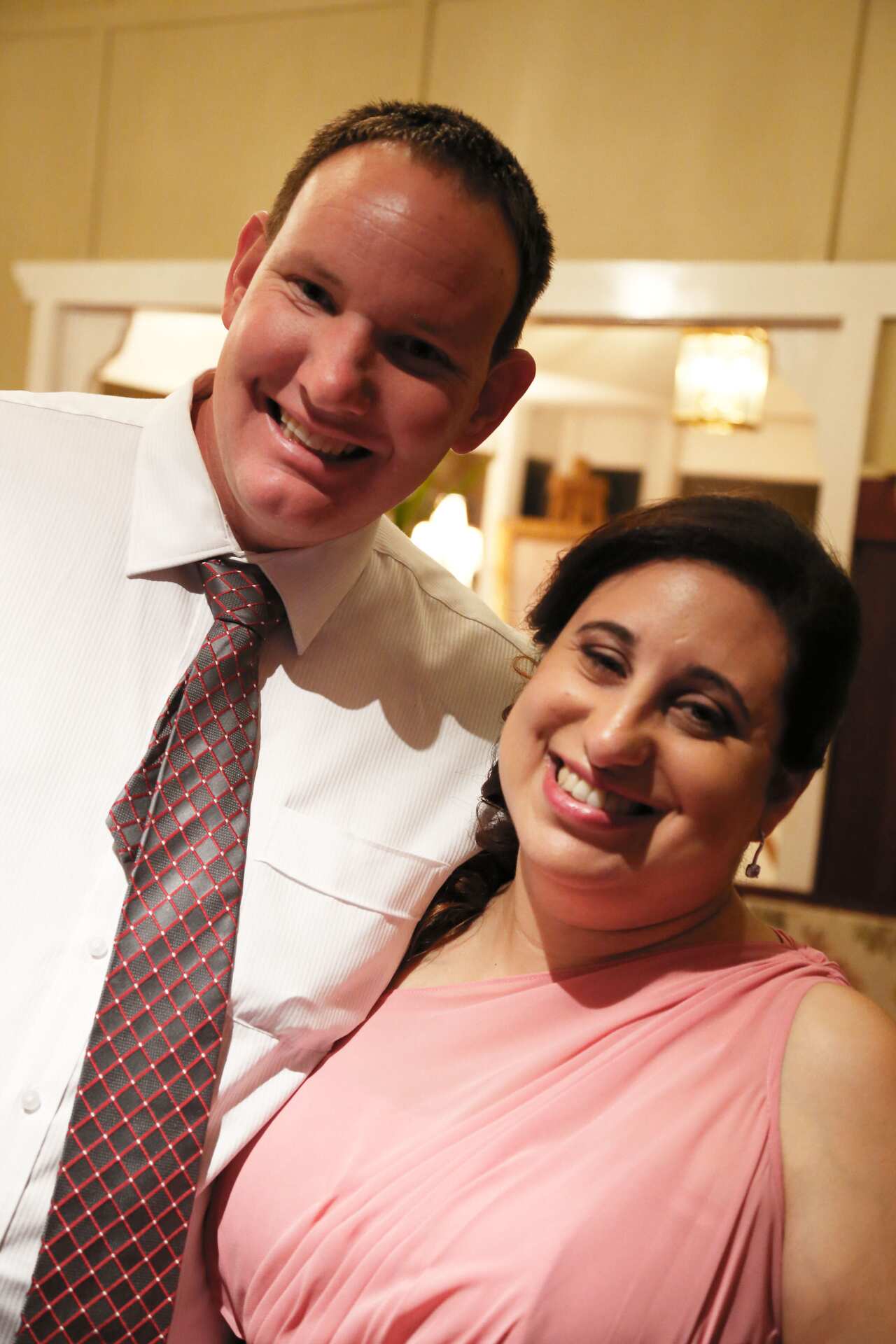 a woman wearing a teal dress looking up at a man wearing a white shirt