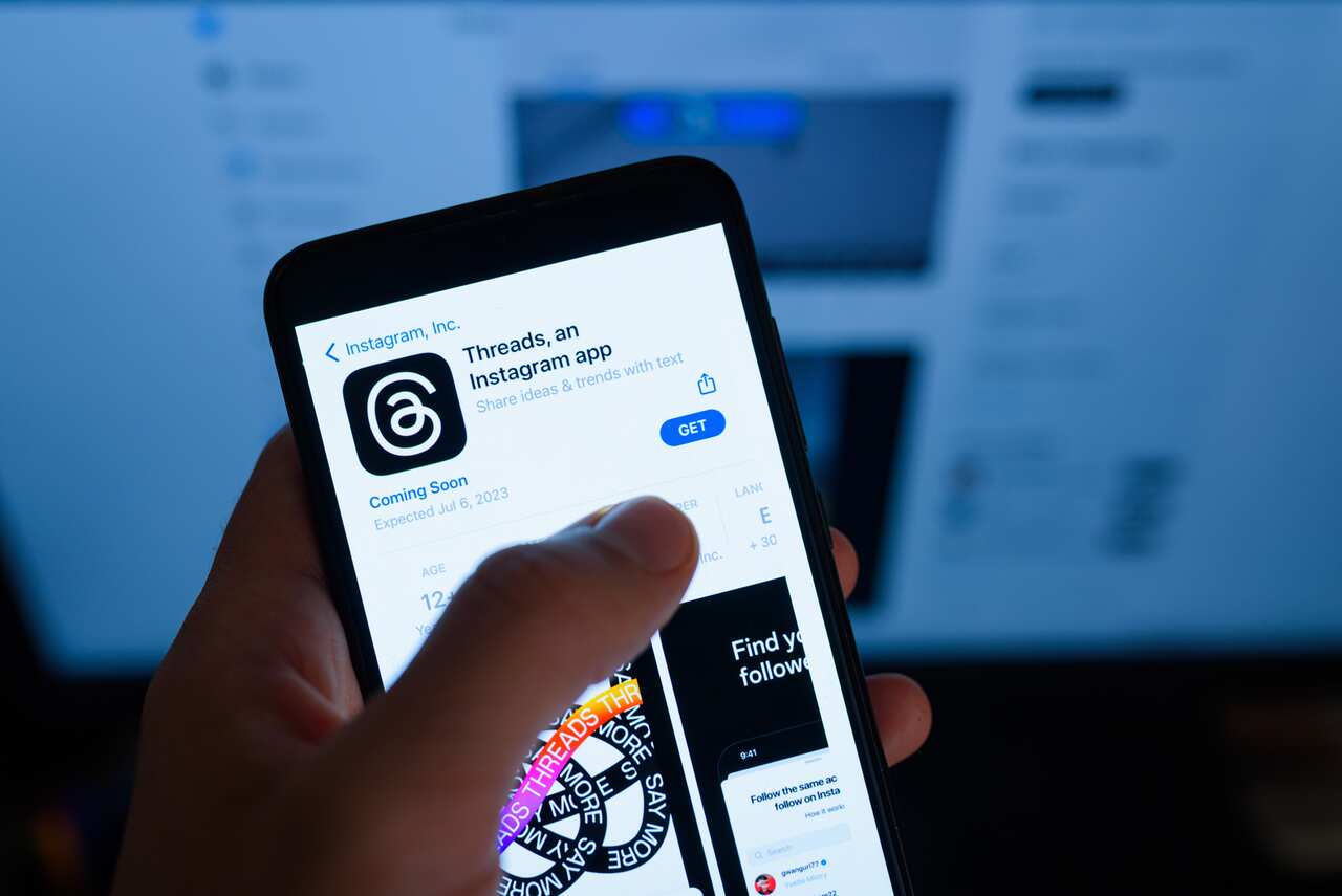 The app Threads from Meta is seen being downloaded on a mobile phone
