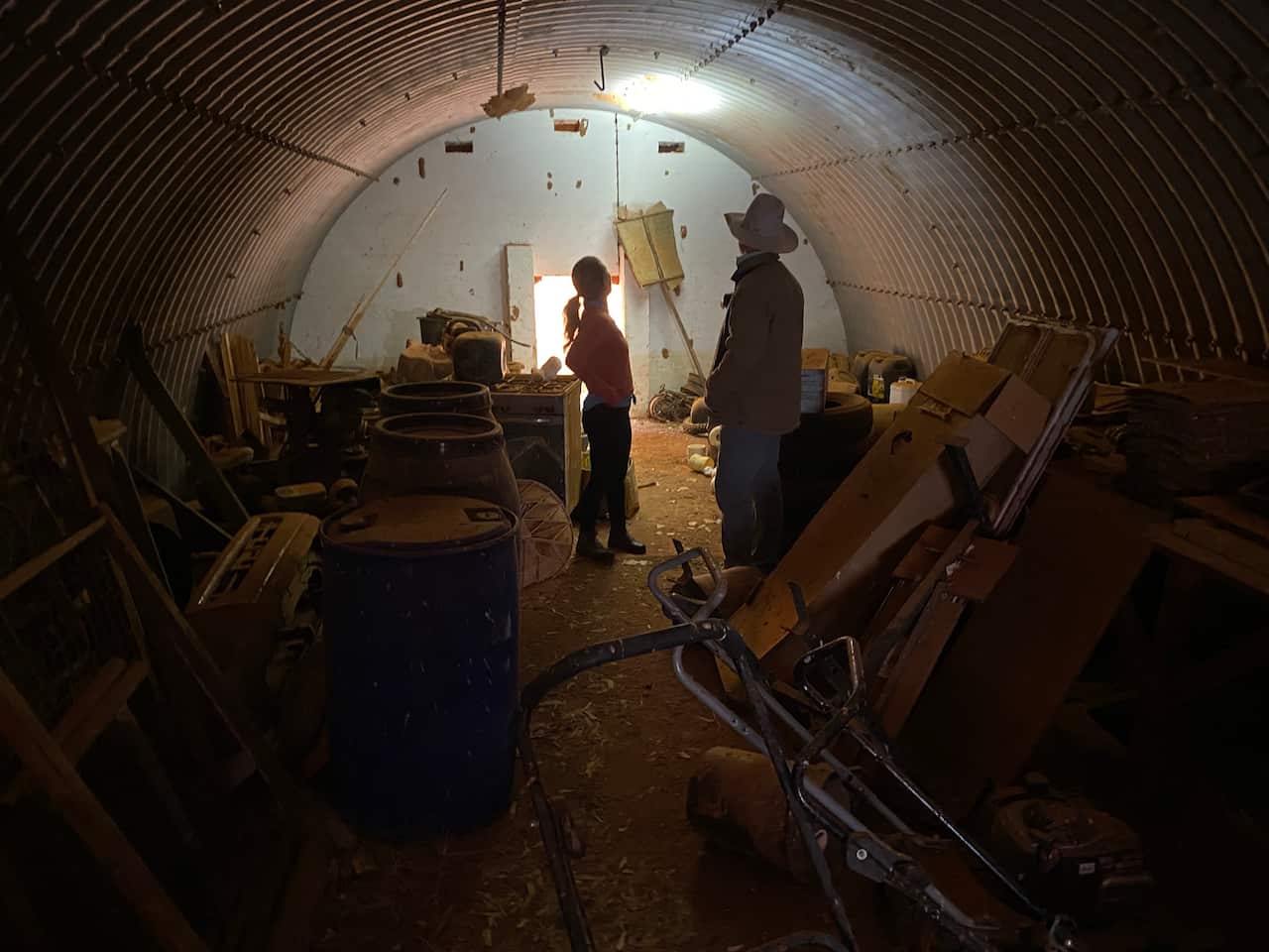 A man and a woman inspect a makeshift bomb shelter.