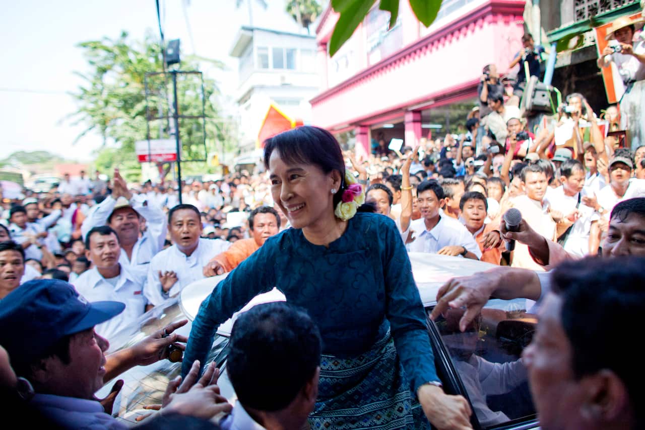 Aung San Suu Kyi surrounded by a cheering crowd in Myanmar.