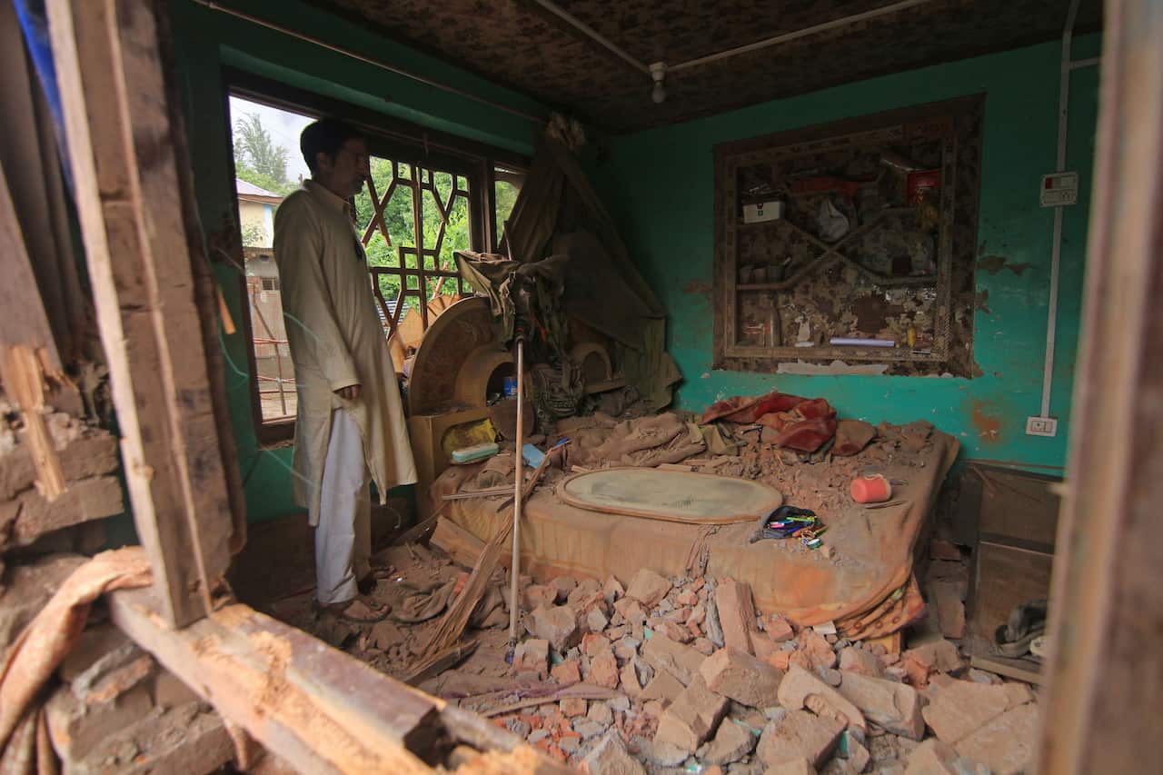 A man inspecting the damage to a house.