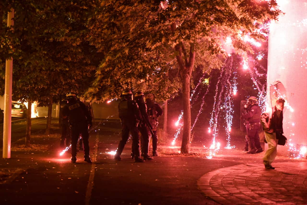 A firework explodes on a number of police officers amidst a protest.