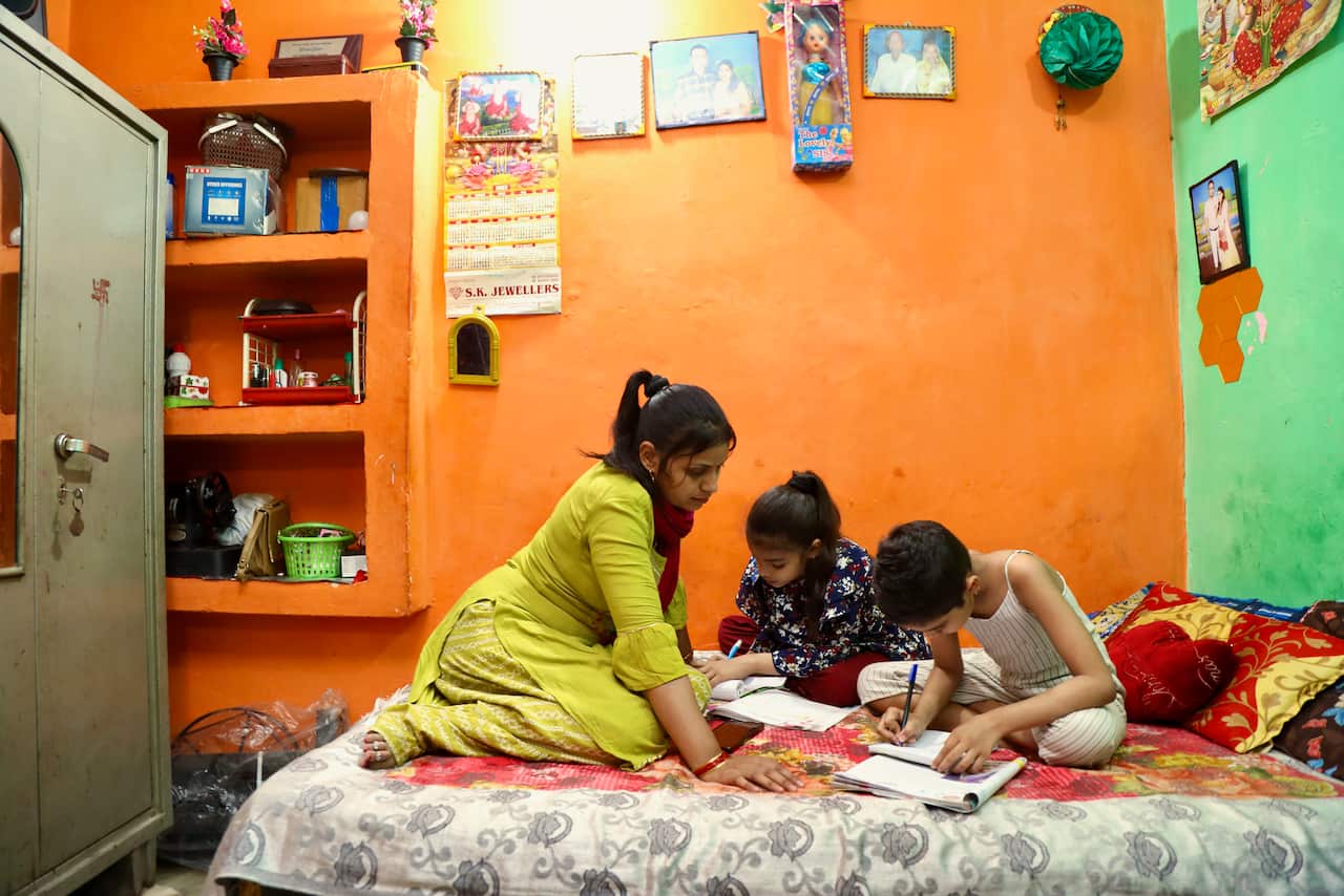 A woman and two children on a bed