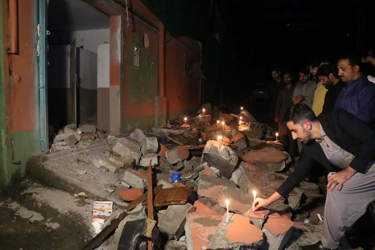 People lighting candles during a vigil.