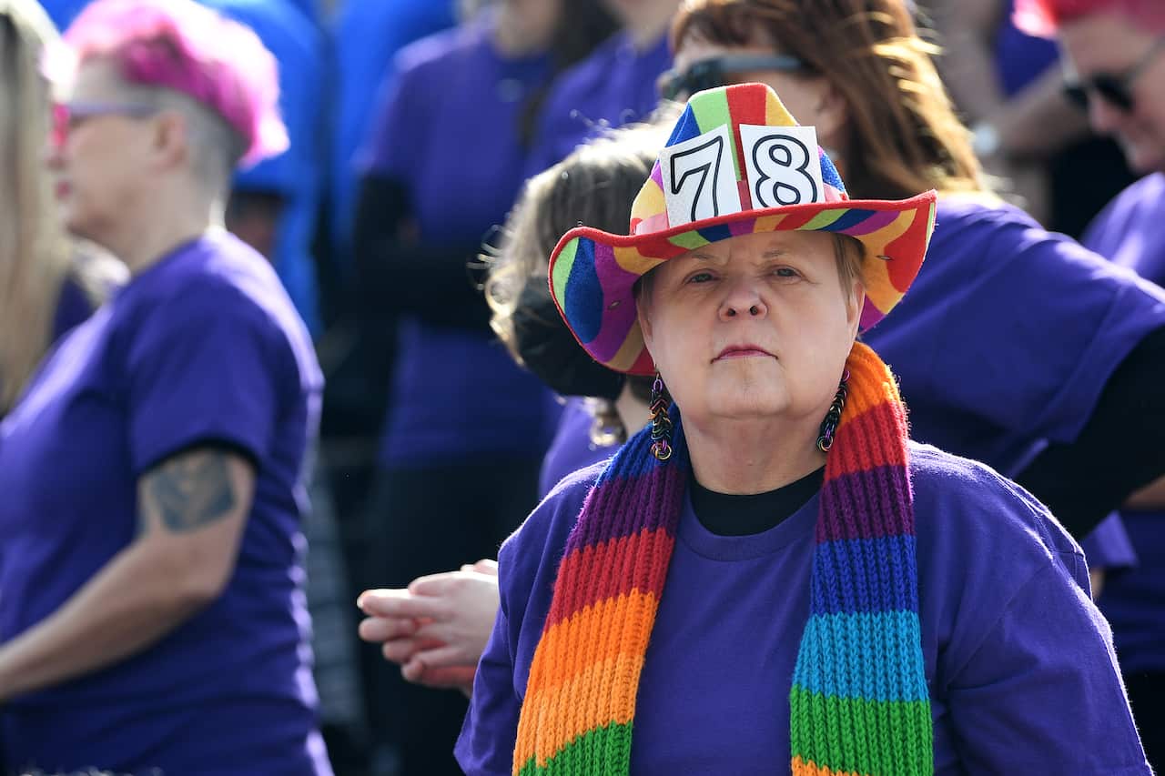 A person in a rainbow striped hat with the numbers 78 on it