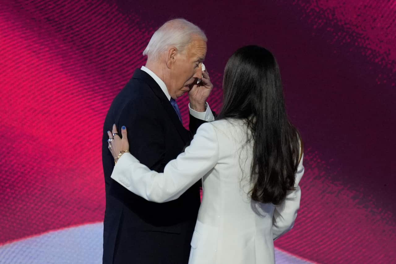 US President Joe Biden wipes his eyes, with daughter Ashley Biden embracing him.