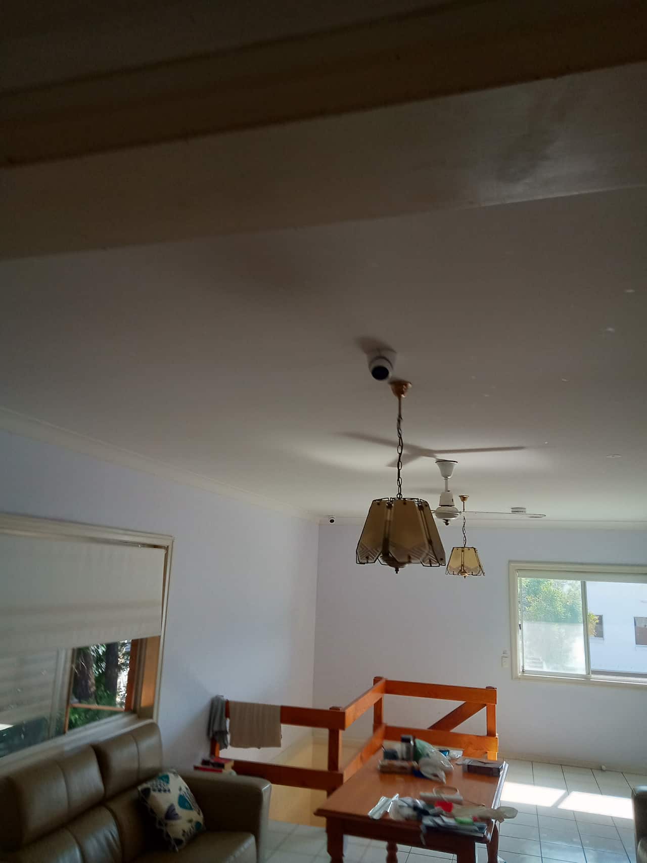 A living room with a surveillance camera mounted on the ceiling.