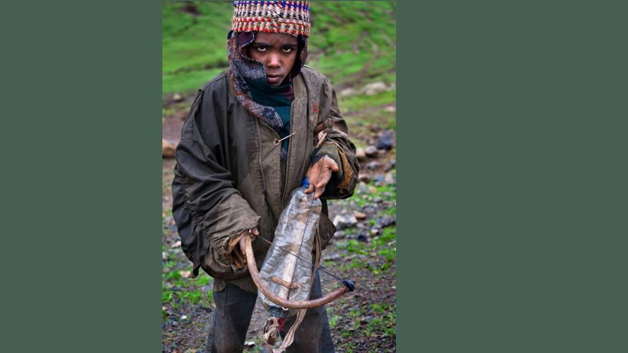 A child plays a musical instrument, similar to a violin (Mesenko).jpg