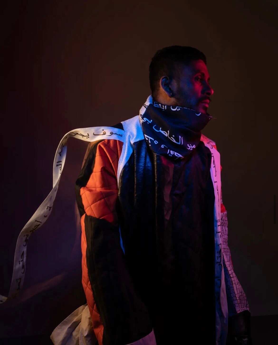 Model standing wearing threads of clothing in Arabic. 