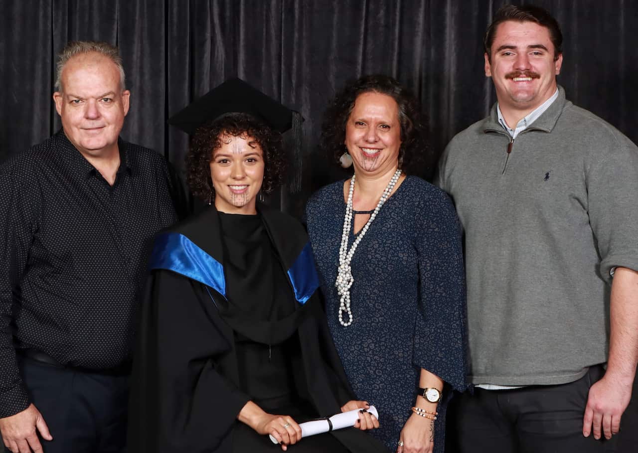 Two women with facial markings stand with two men