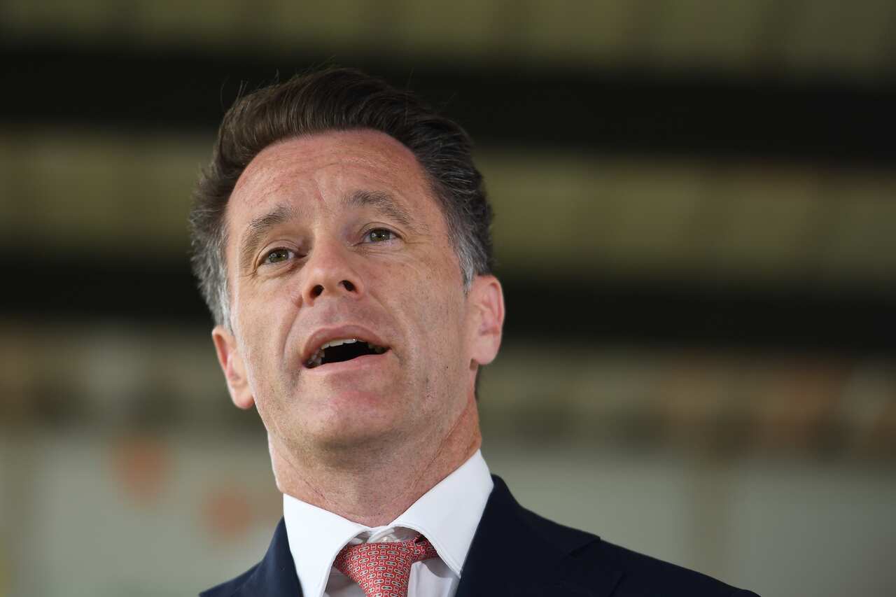 A man wearing a suit and tie is speaking.