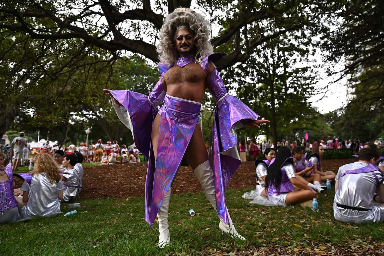 A drag queen dressed in costume standing in a park
