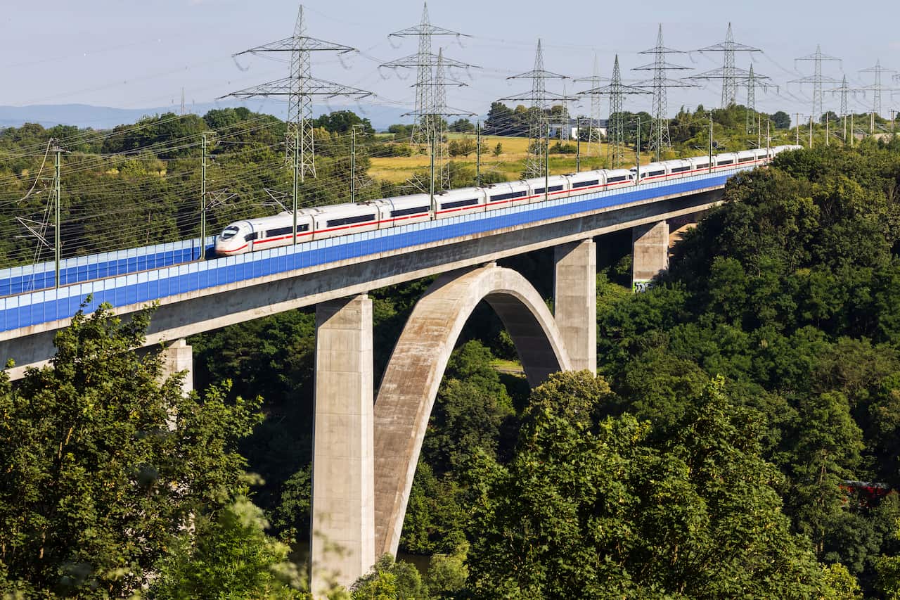 A high-speed train crosses a bridge.