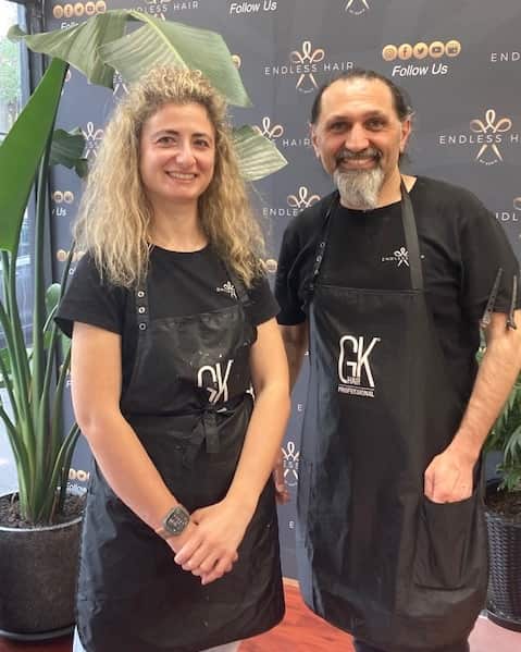 Photo of a woman and man wearing aprons smiling together. 