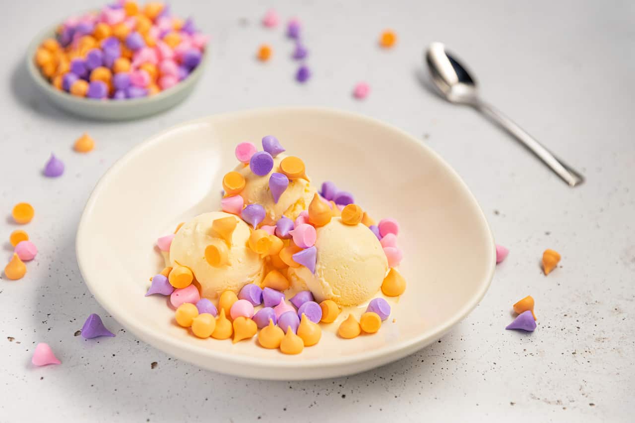 Little pink, purple and orange meringue confetti are a colourful dessert served with ice-cream.