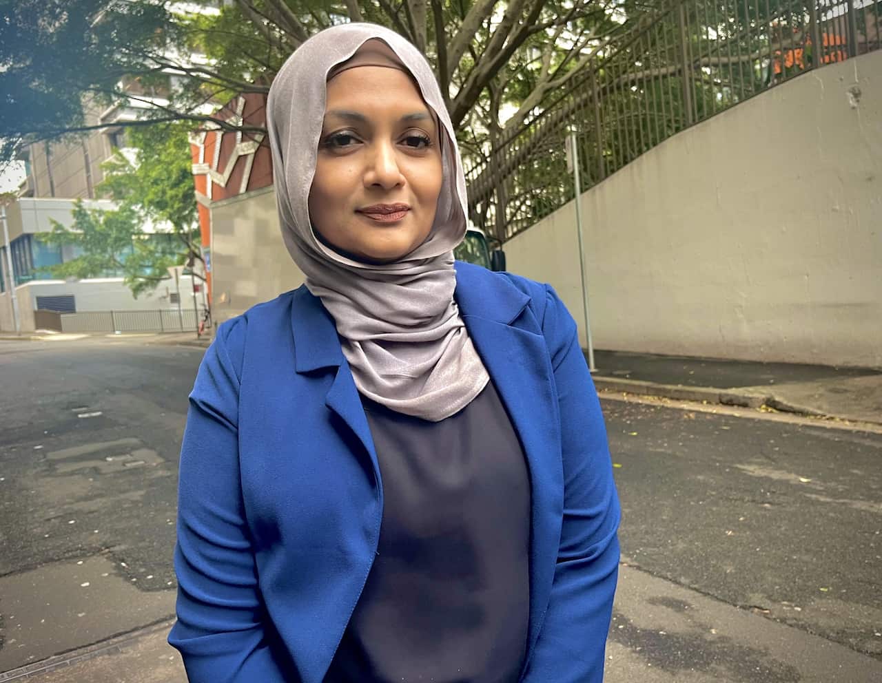 A woman in a headscarf and suit jacket